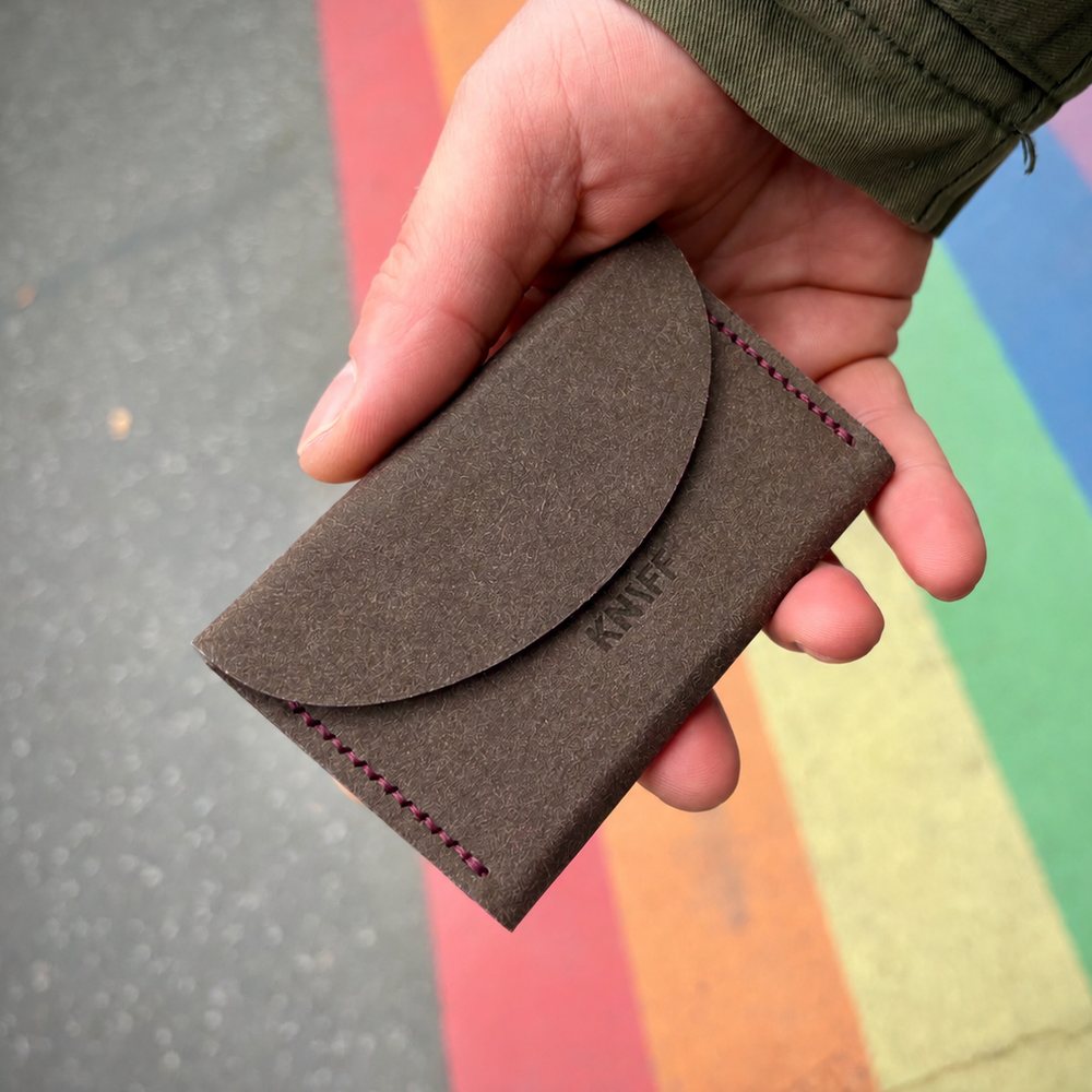 Vegane Geldbörse KNIFF in Walnuss (Hanf) mit Naht in Magenta, in der Hand